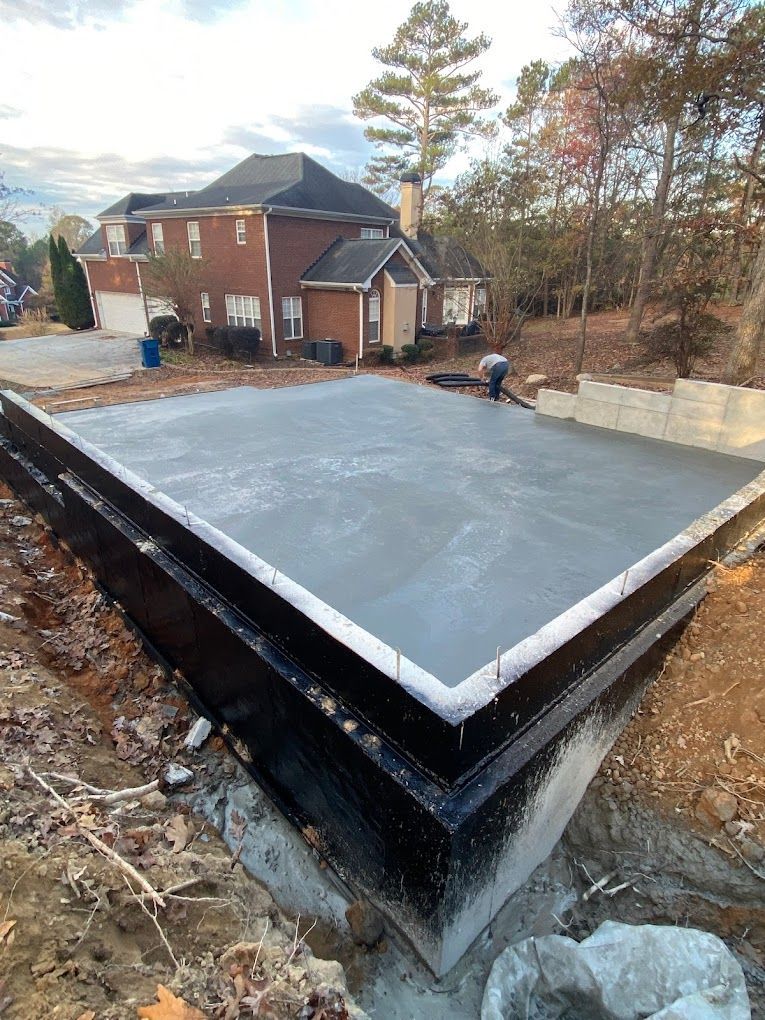A concrete base is being built in front of a house.