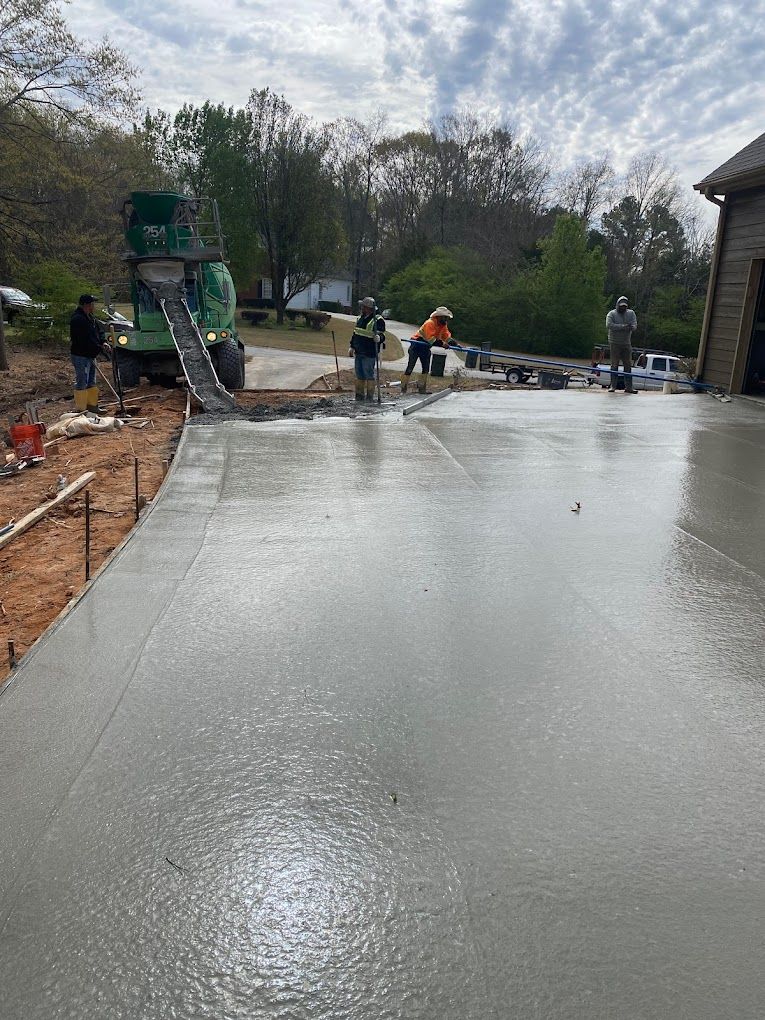 A group of people are working on a concrete driveway.