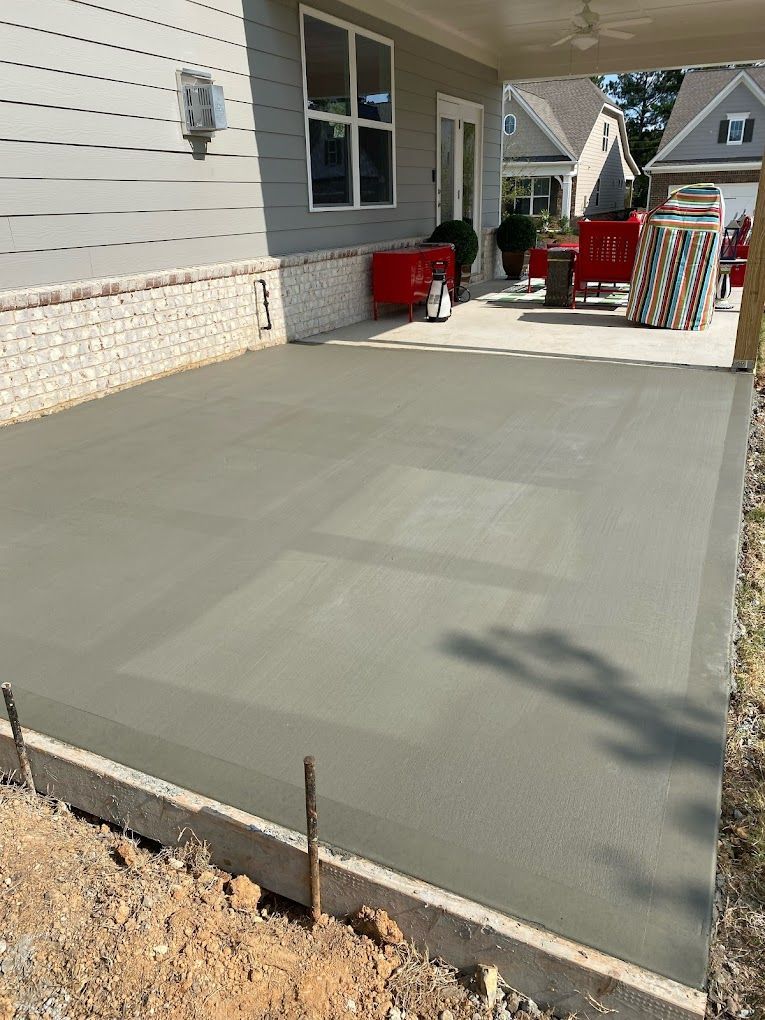 A concrete patio is being built in front of a house.