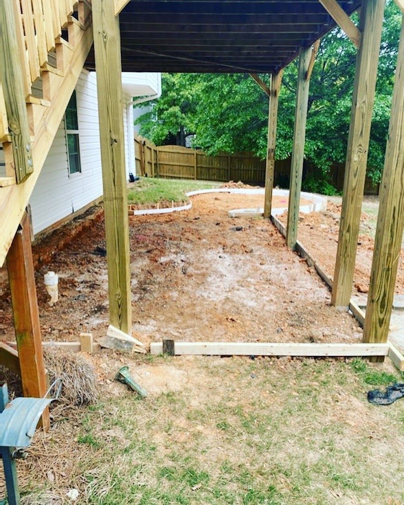 A wooden deck is being built in the backyard of a house