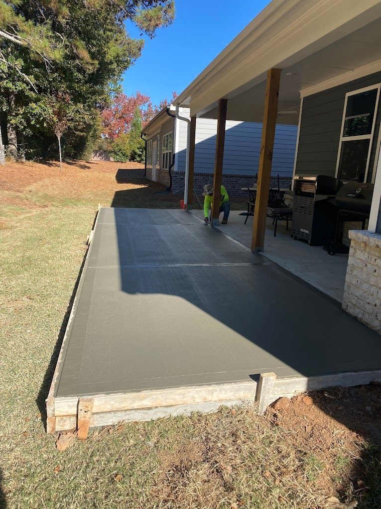 A concrete walkway is being built in front of a house.