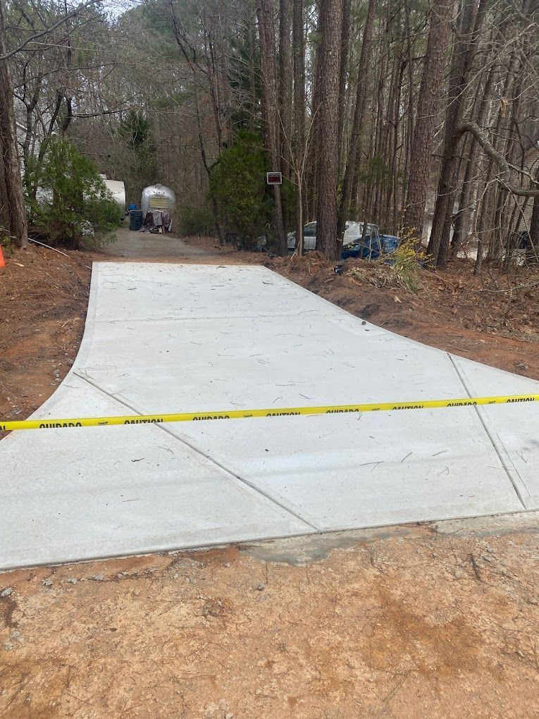 A concrete driveway is being built in the middle of a forest.