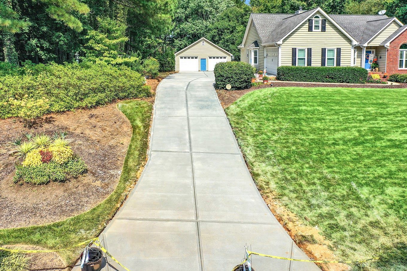 An aerial view of a concrete driveway leading to a house.