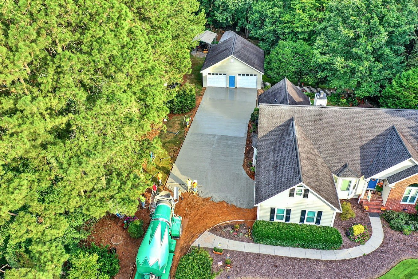 An aerial view of a house with a green truck parked in front of it.