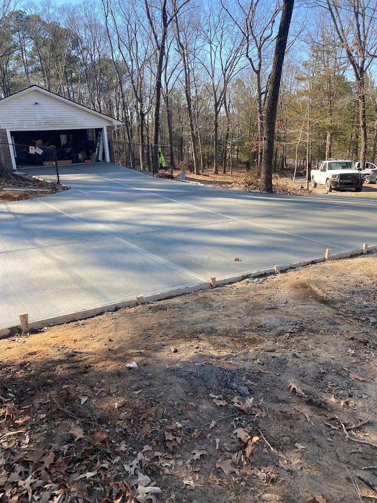 A concrete driveway is being built in front of a garage.