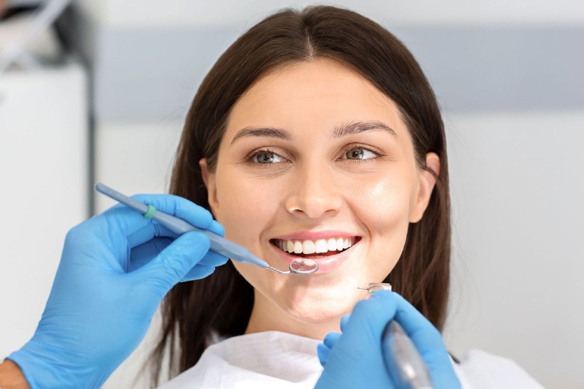 A woman is getting her teeth examined by a dentist.