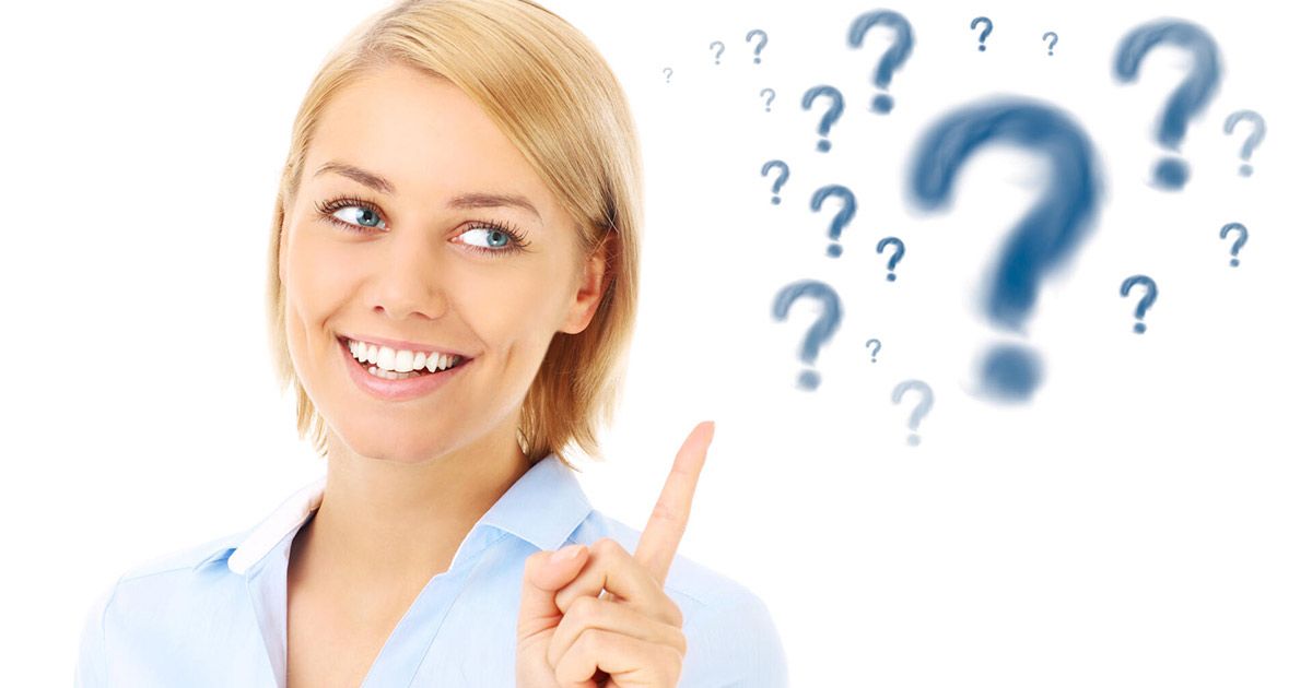 A woman is pointing up at a bunch of question marks.