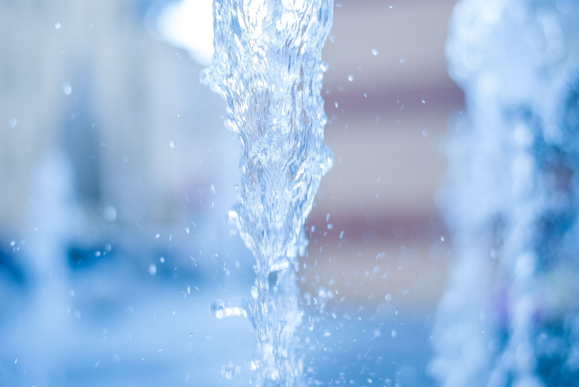 Close-up of a gush of water in front of a blurry background.