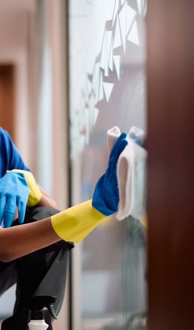 Workers cleaning a wet floor with mops and a floor scrubber inside a building Workers cleaning a wet floor with mops and a floor scrubber inside a building