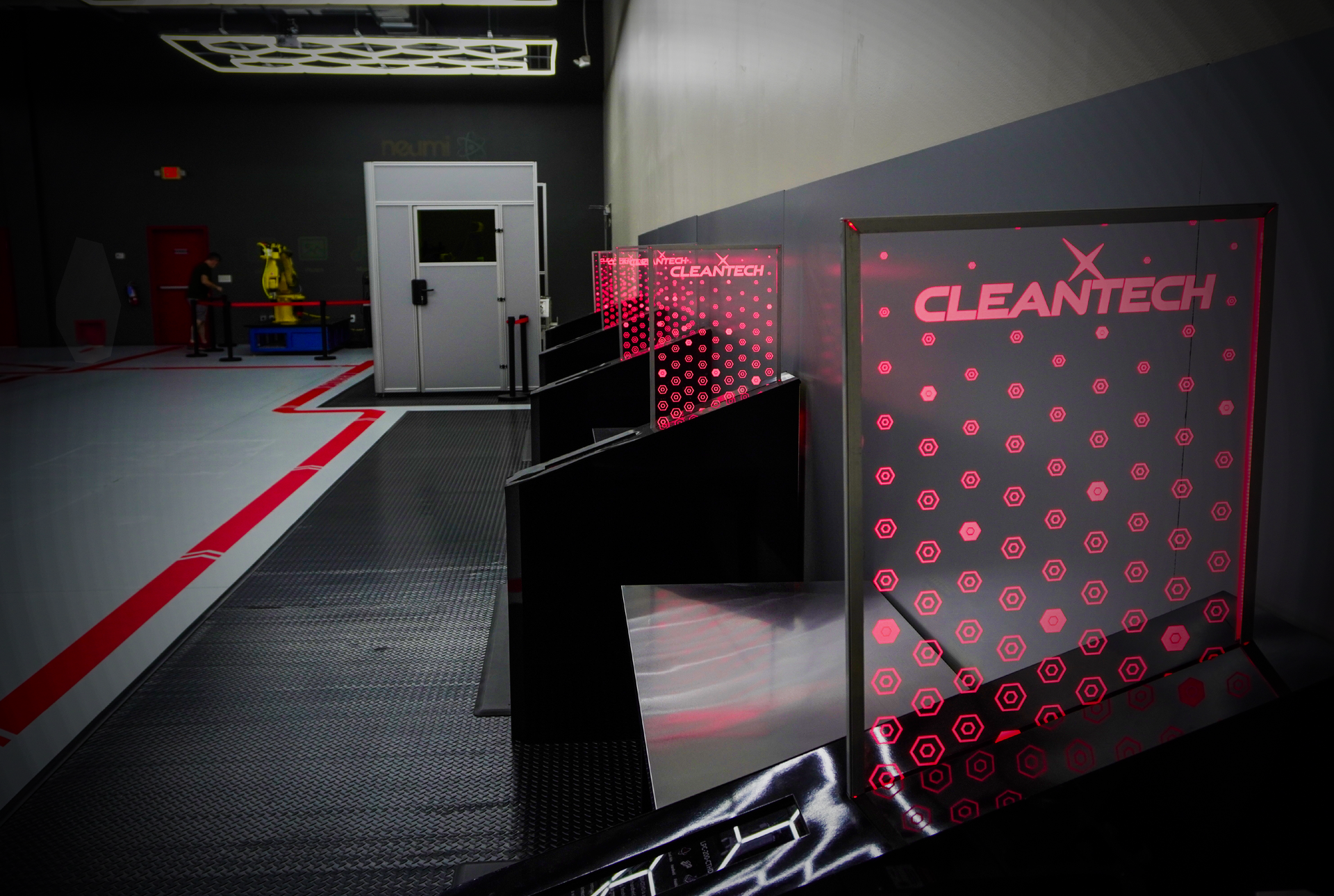 A laboratory interior with CleanTech sign, angled black display stands, and a large white cabinet.