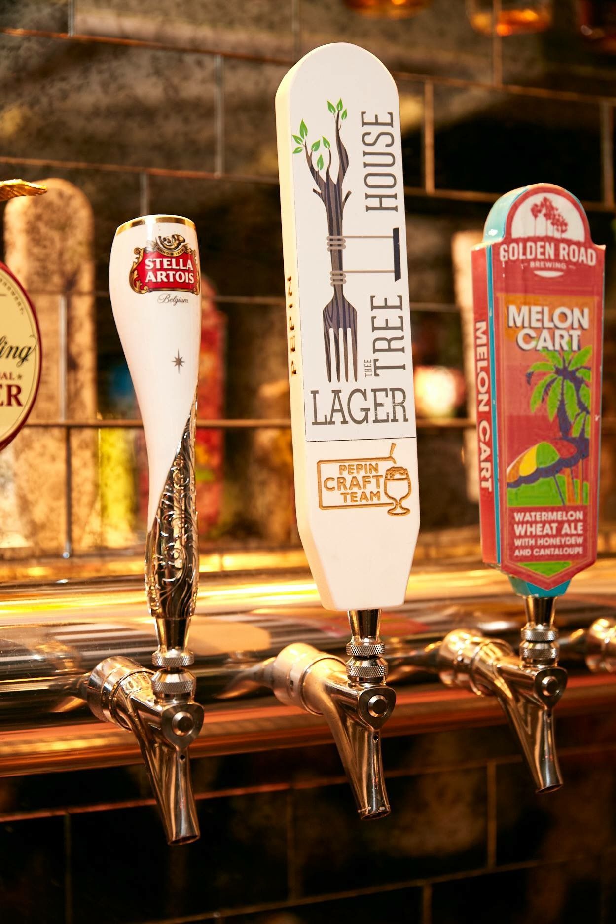 Three beer taps: Stella Artois, Tree House Lager, and Golden Road Melon Cart.