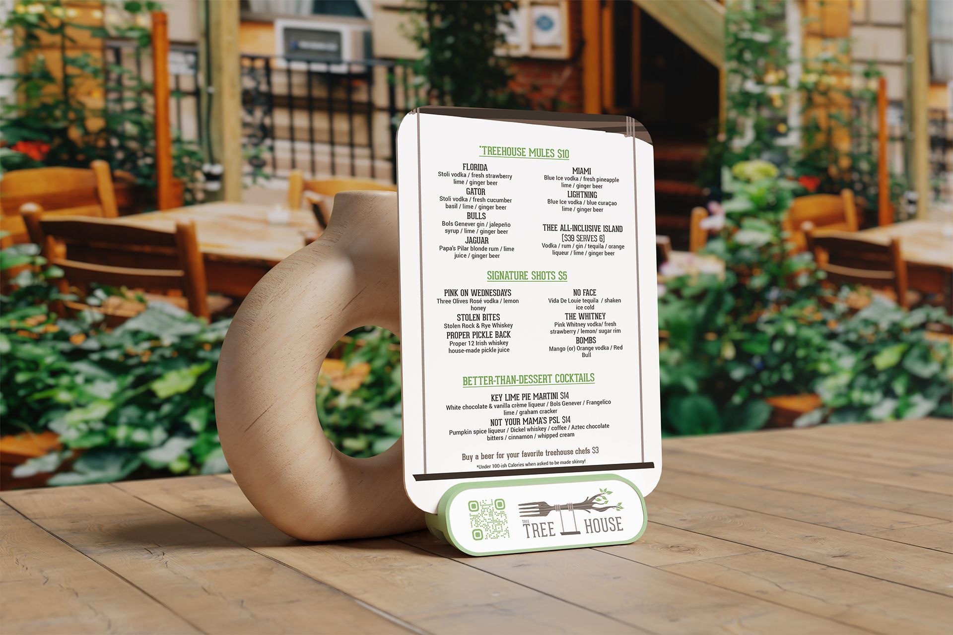 A menu on a restaurant table. It's held in a curved beige holder with a QR code base and outdoor seating background.