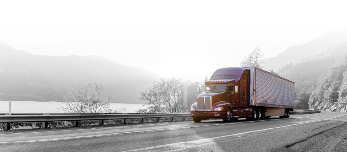 A semi truck is driving down a mountain road.