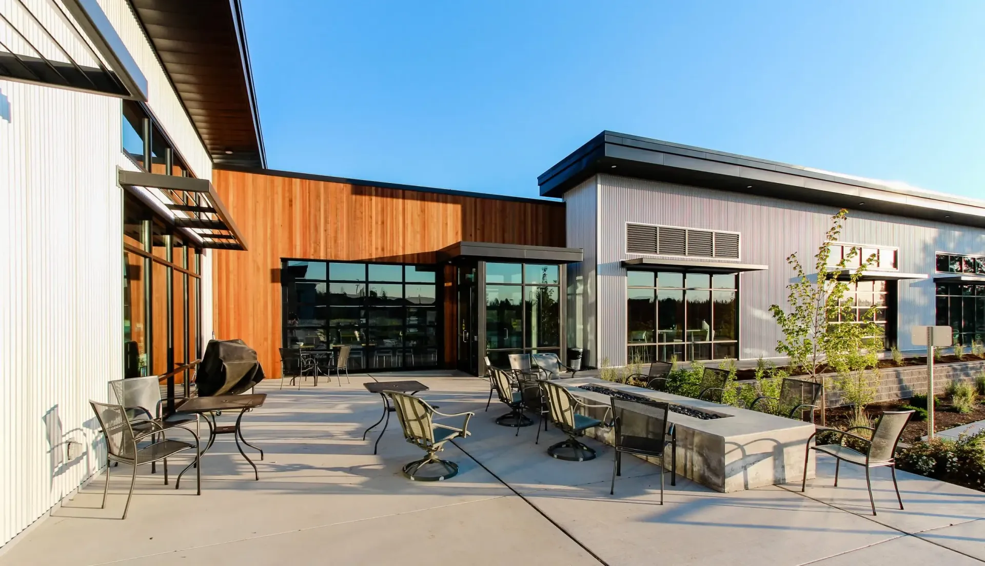 a patio with tables and chairs in front of a building .