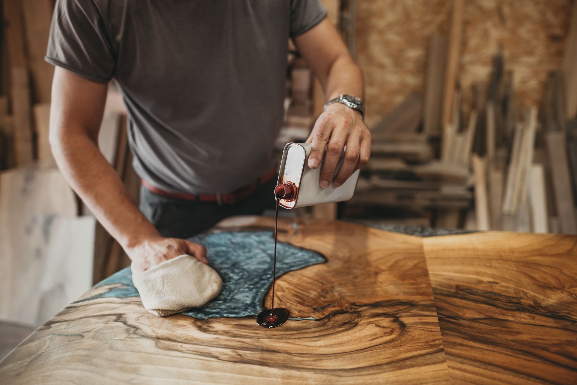 A handyman is shown working in his workshop, surrounded by various tools and pieces of wood.