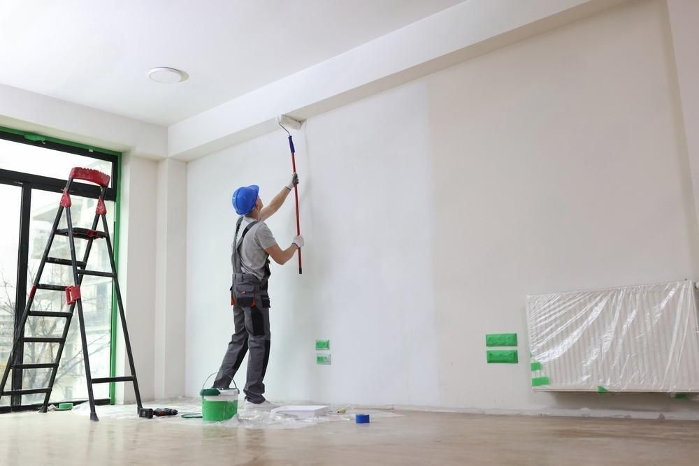 a man is painting a wall with a roller