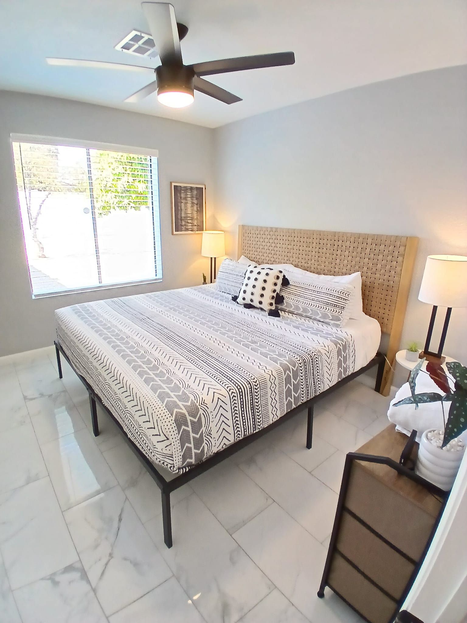 A bedroom with a king size bed and a ceiling fan.