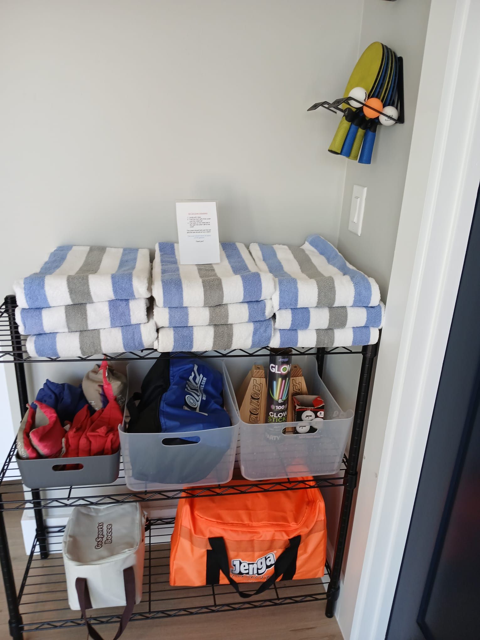 A shelf with striped towels and a bag on it