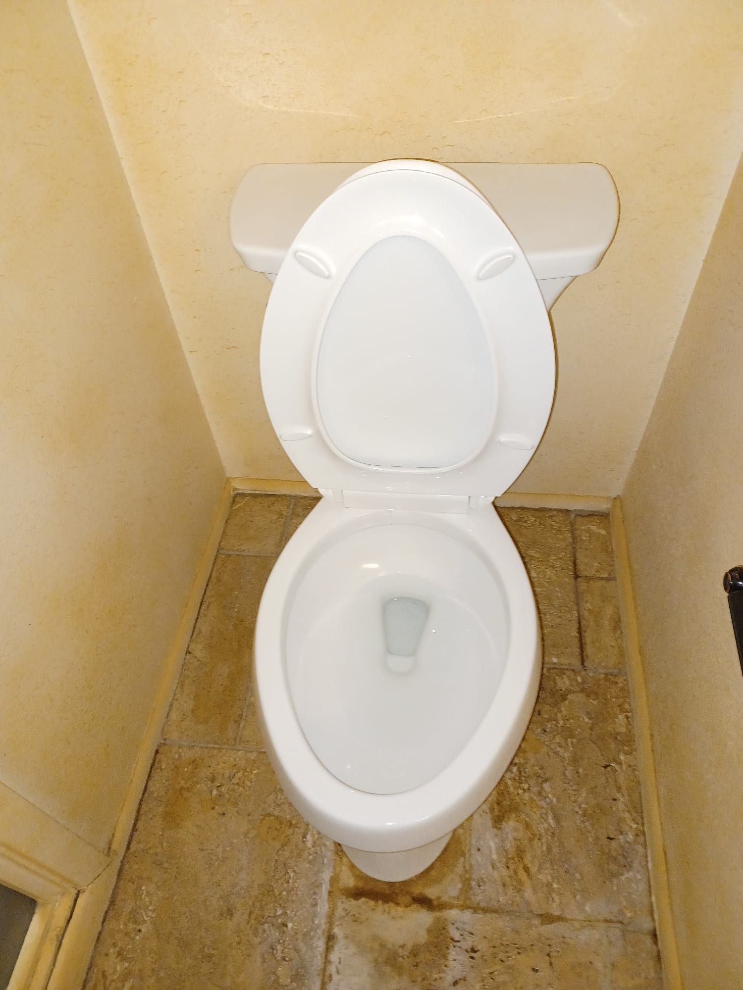 A white toilet with the lid up in a bathroom
