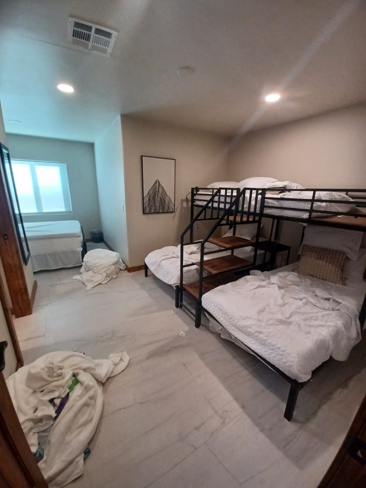 A bedroom with three bunk beds and two twin beds.