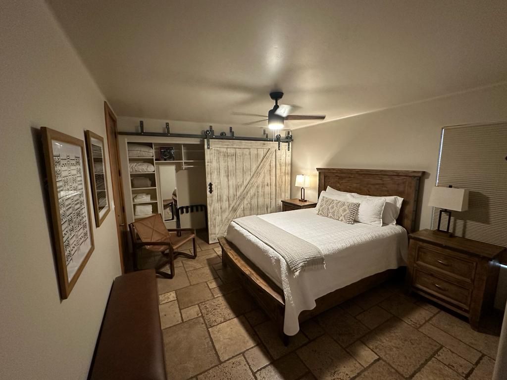 A bedroom with a king size bed and a sliding barn door.