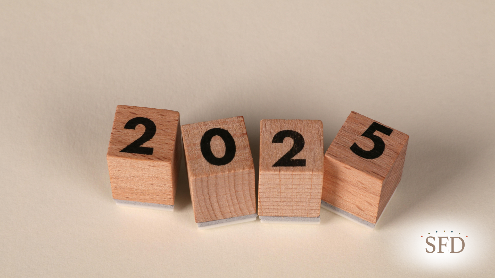Wooden blocks spell out the year 2025.