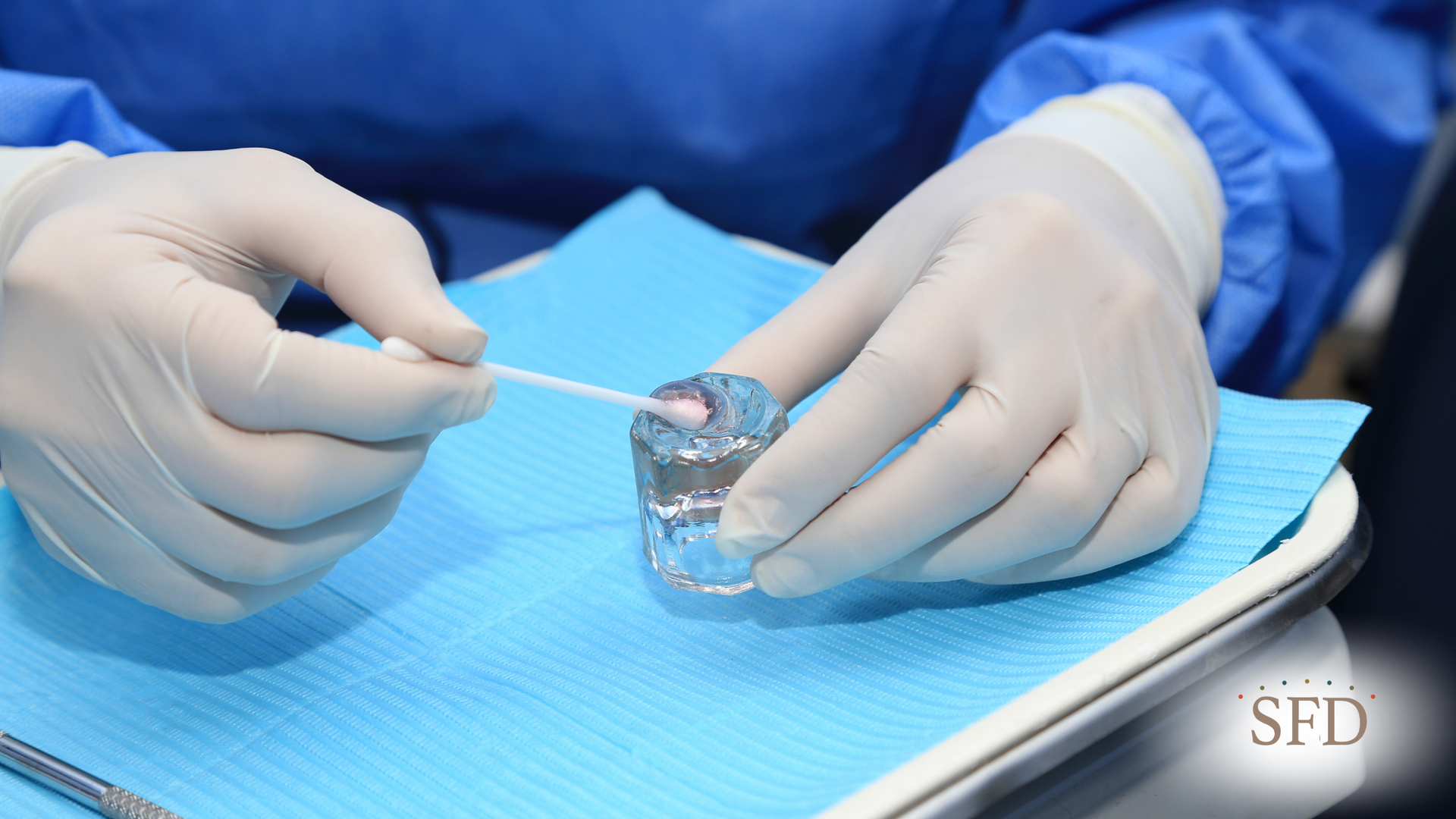 A dentist is cleaning a tooth with a cotton swab.