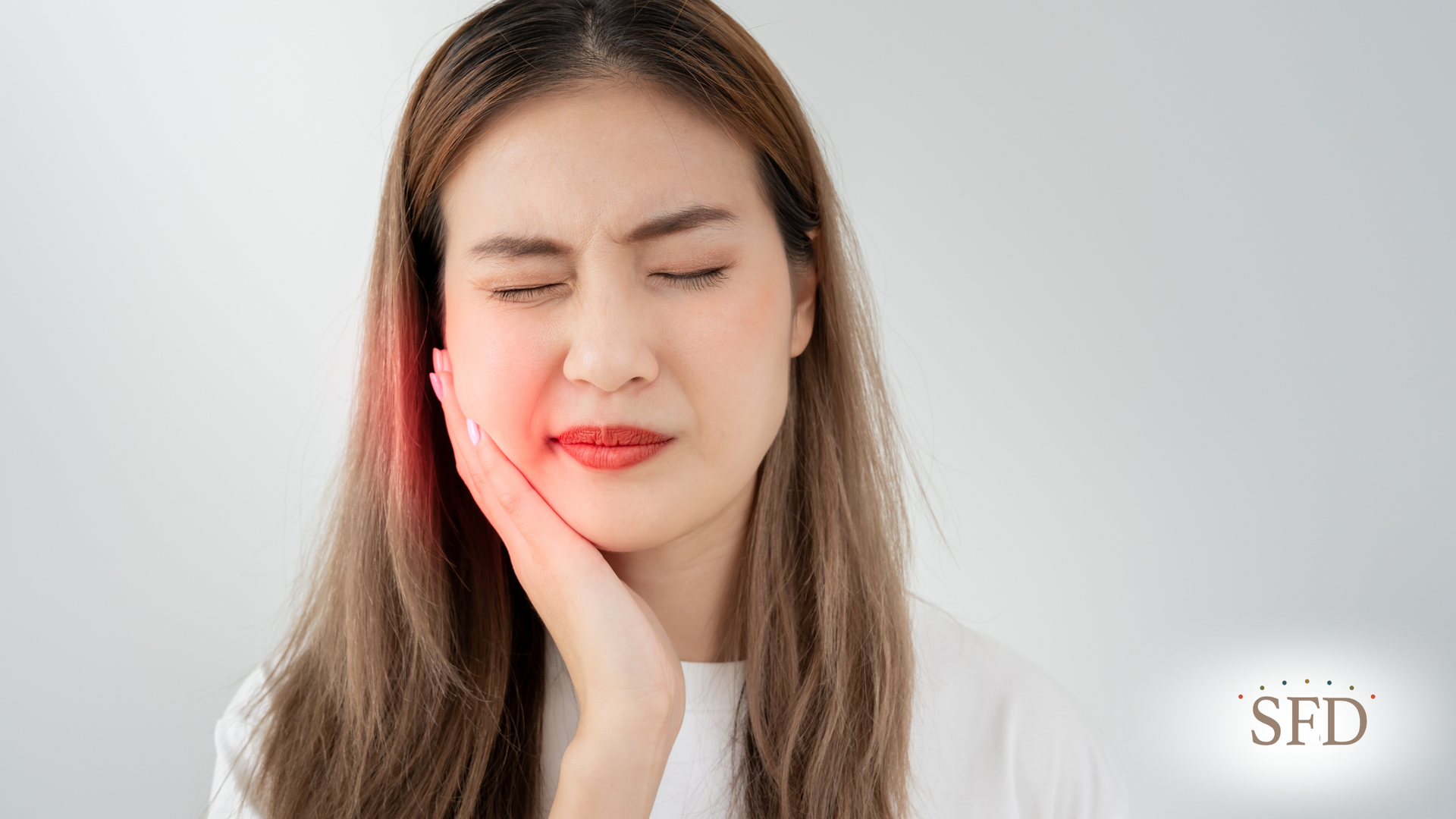 A woman is holding her face in pain because of a toothache.