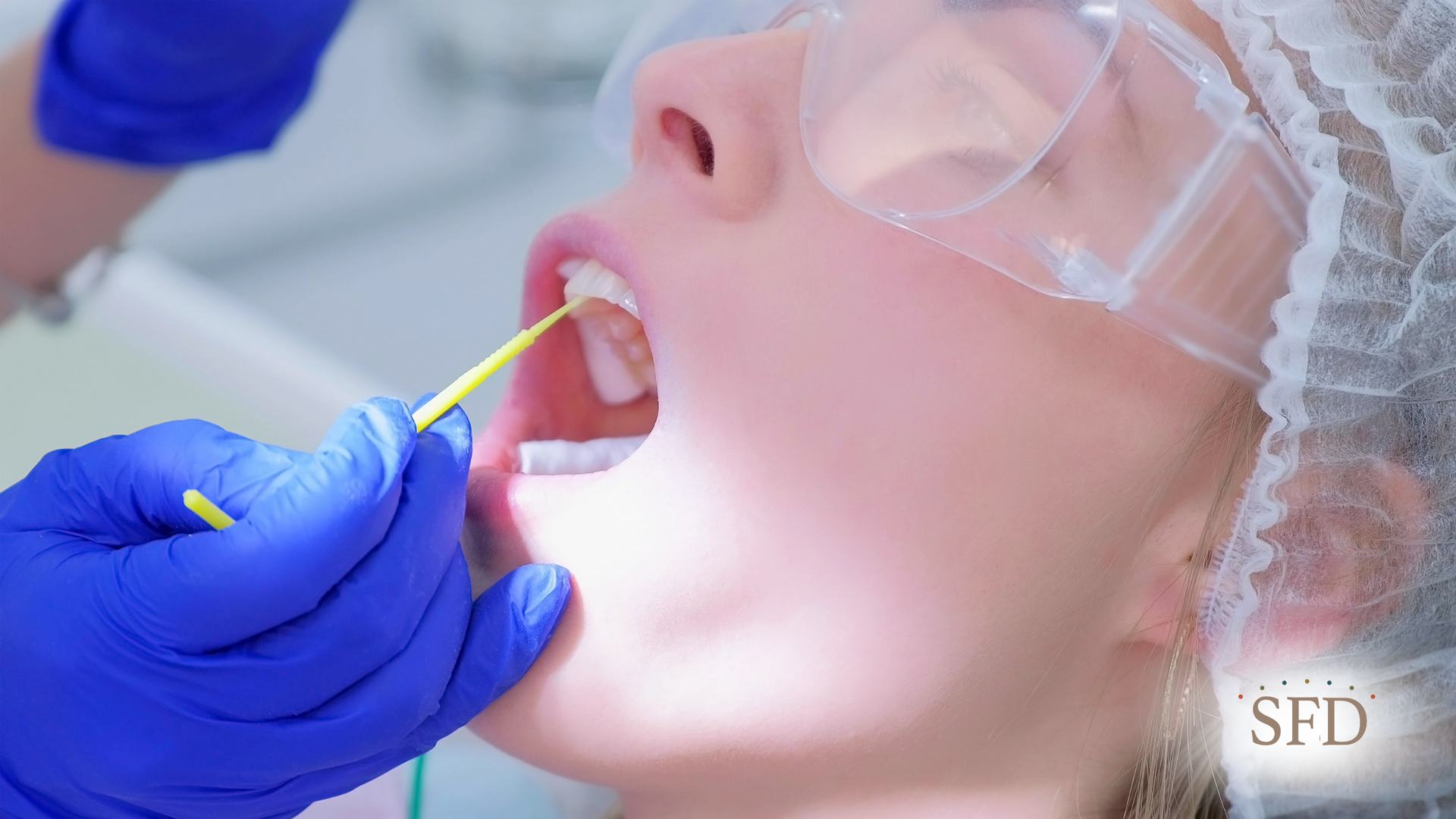 A woman is getting her teeth examined by a dentist.