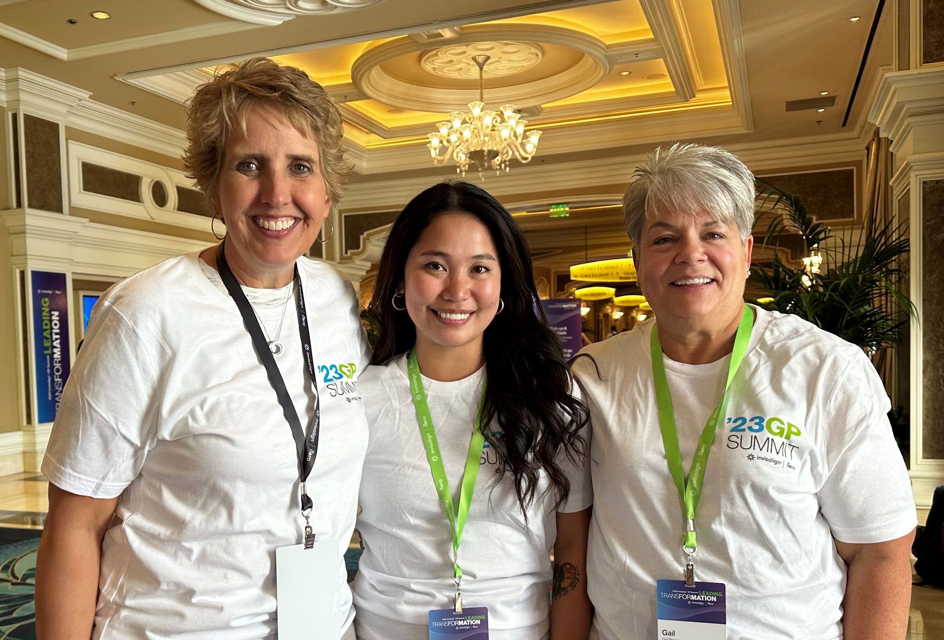 Three women are posing for a picture in a hotel lobby.
