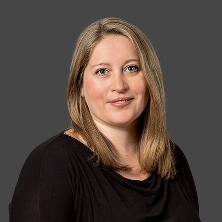 The woman is wearing a black shirt and smiling for the camera.