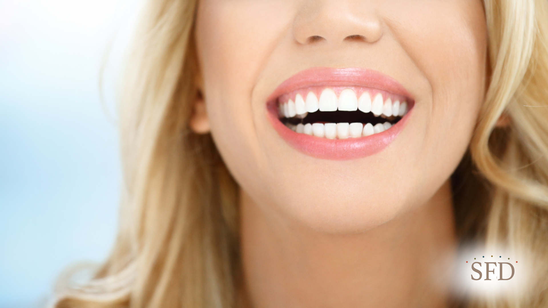 A close up of a woman 's mouth with white teeth.