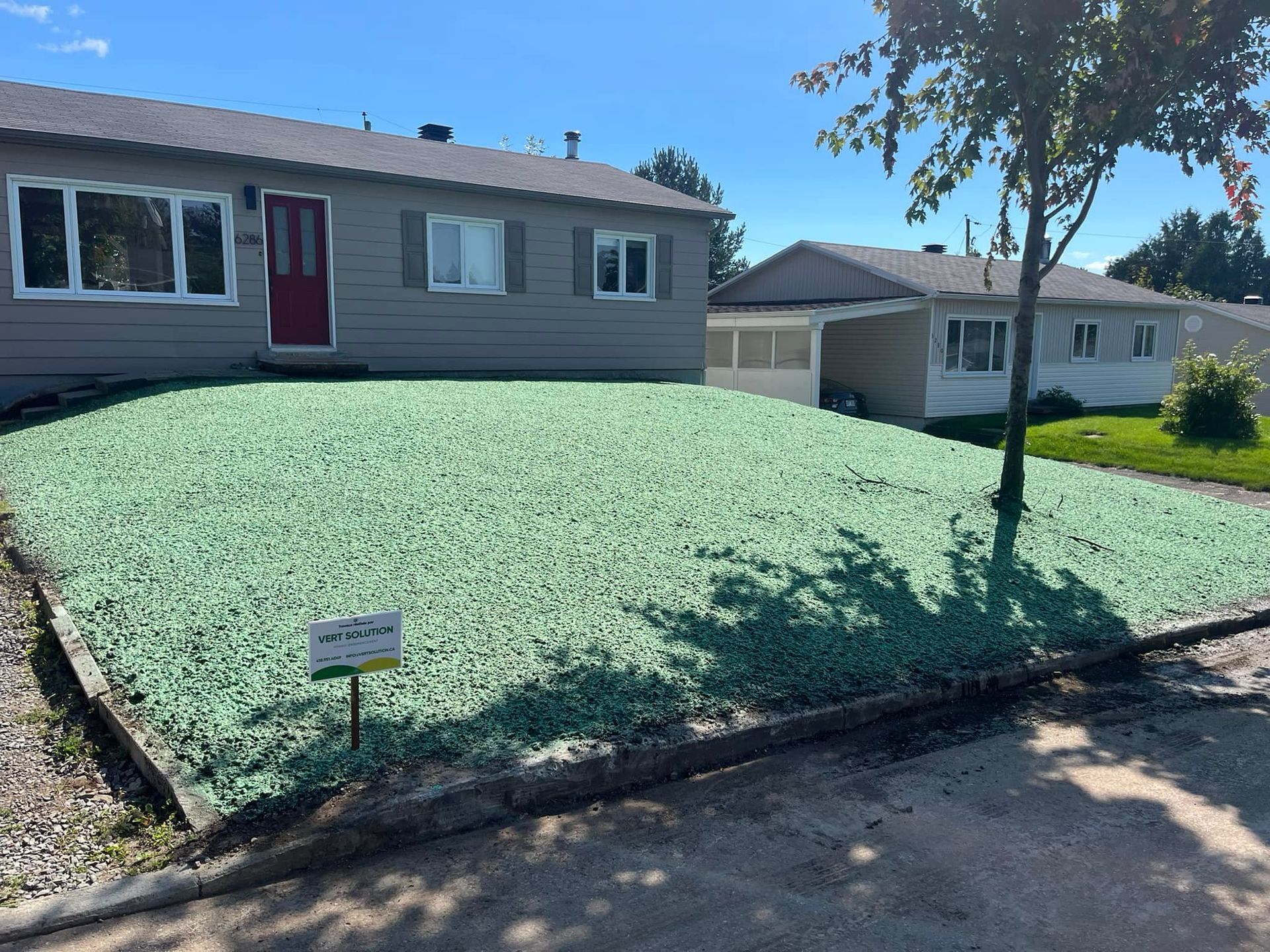 Une maison avec une pelouse verte devant elle