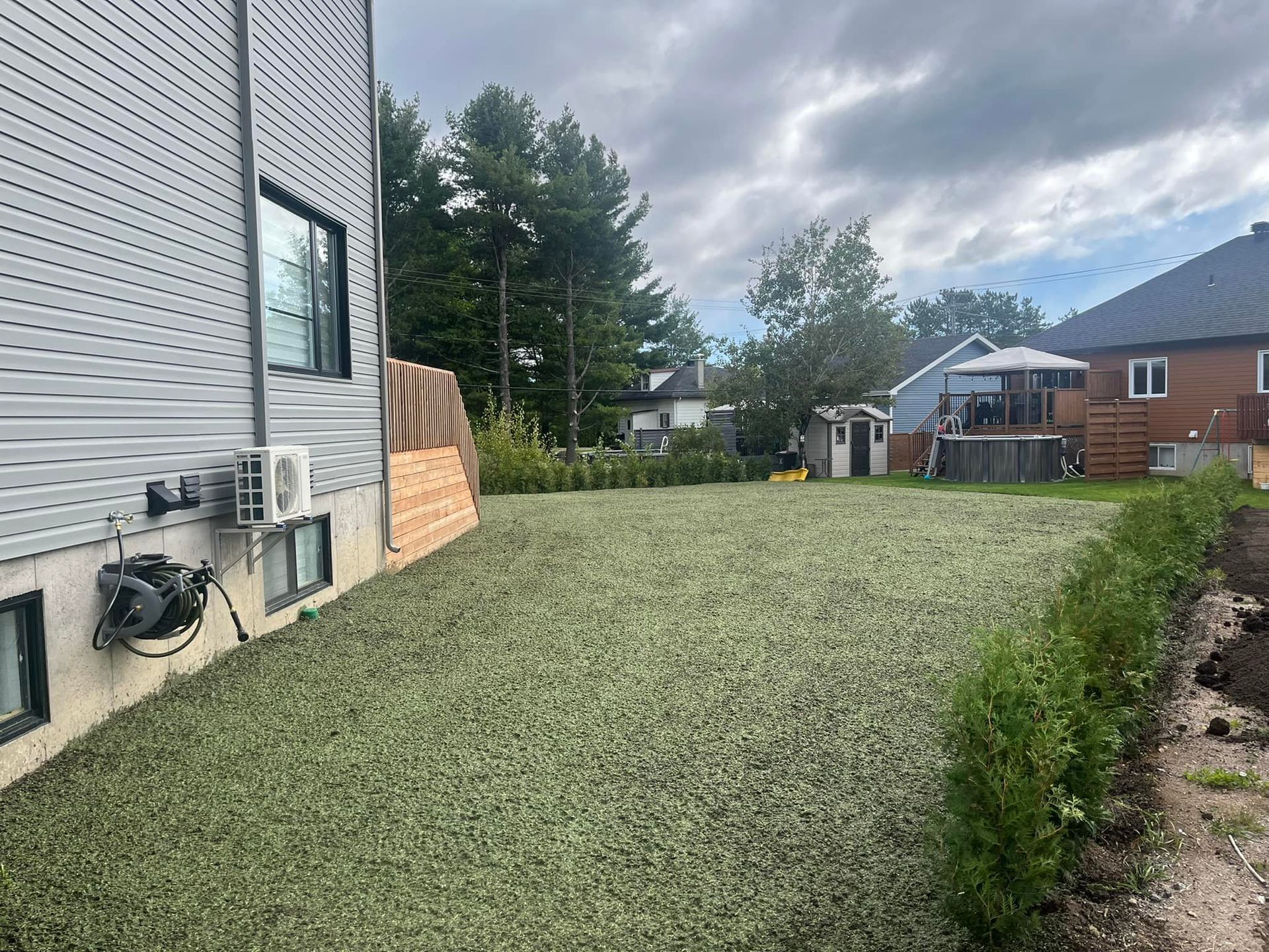 Une cour arrière avec beaucoup d'herbe et une maison en arrière-plan.