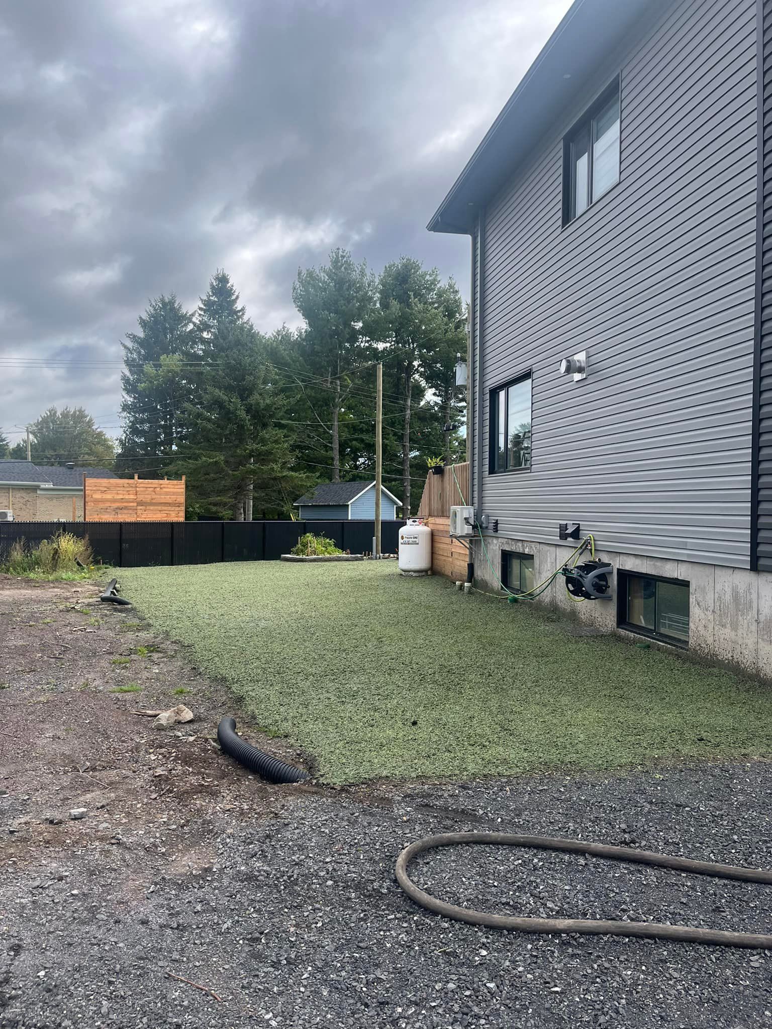 Il y a un tuyau dans l'arrière-cour d'une maison.