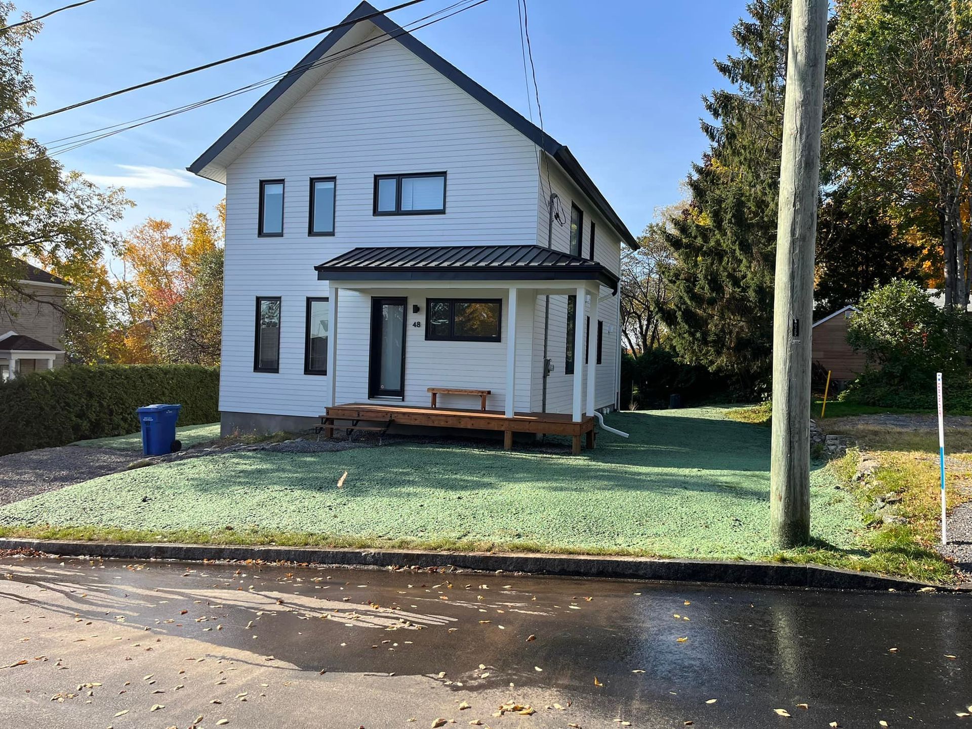 Une maison blanche avec une pelouse verte devant elle