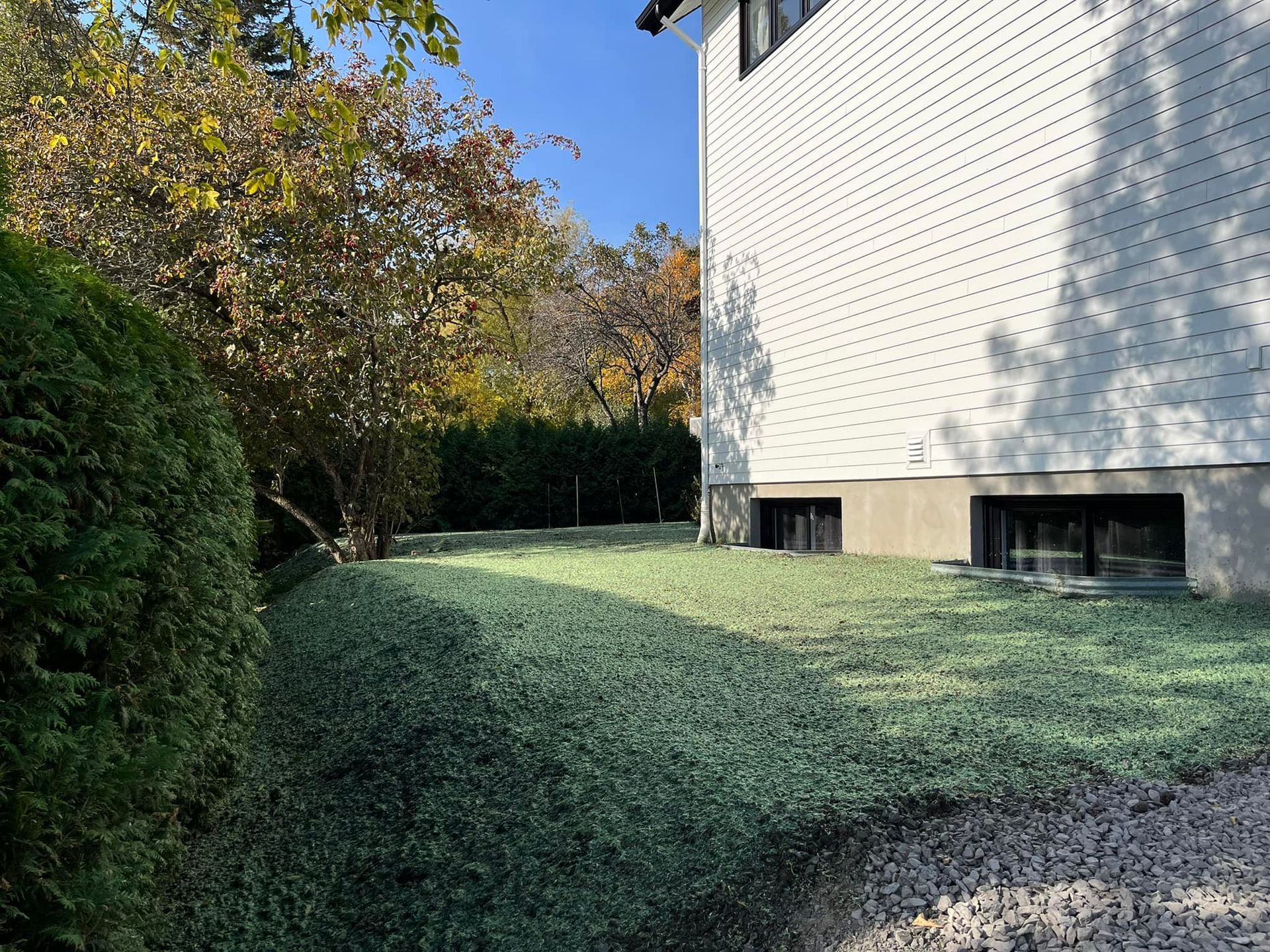 Une maison blanche avec une cour verdoyante devant elle.