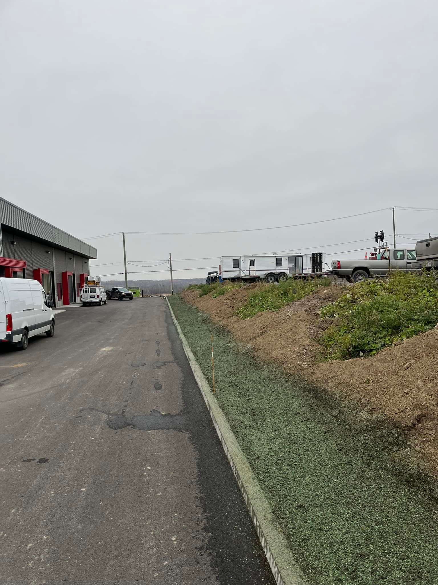 Un camion est garé sur le bord de la route à côté d'un bâtiment.