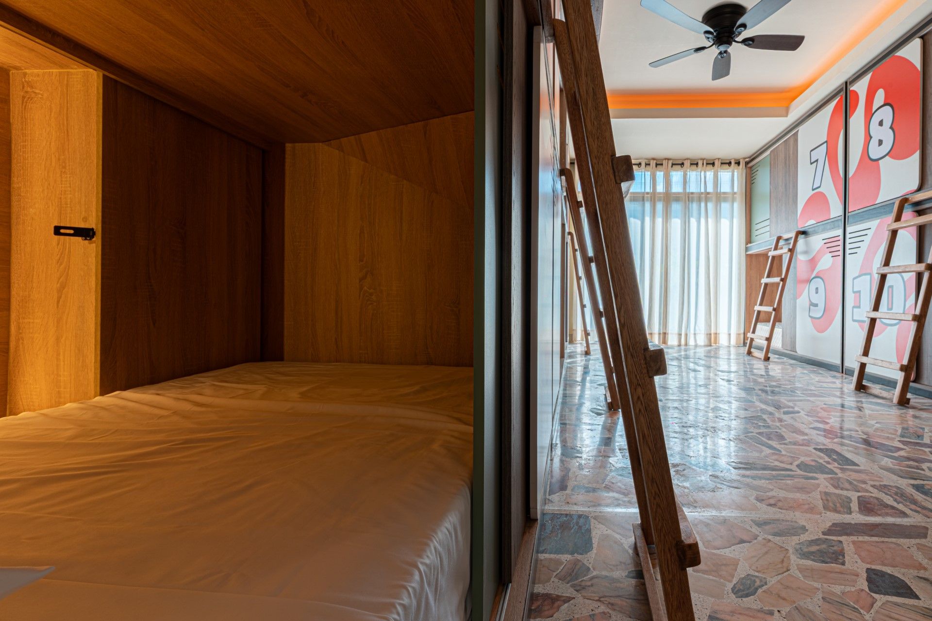 Interior de una habitación con literas. Un lado muestra un cubículo de madera 