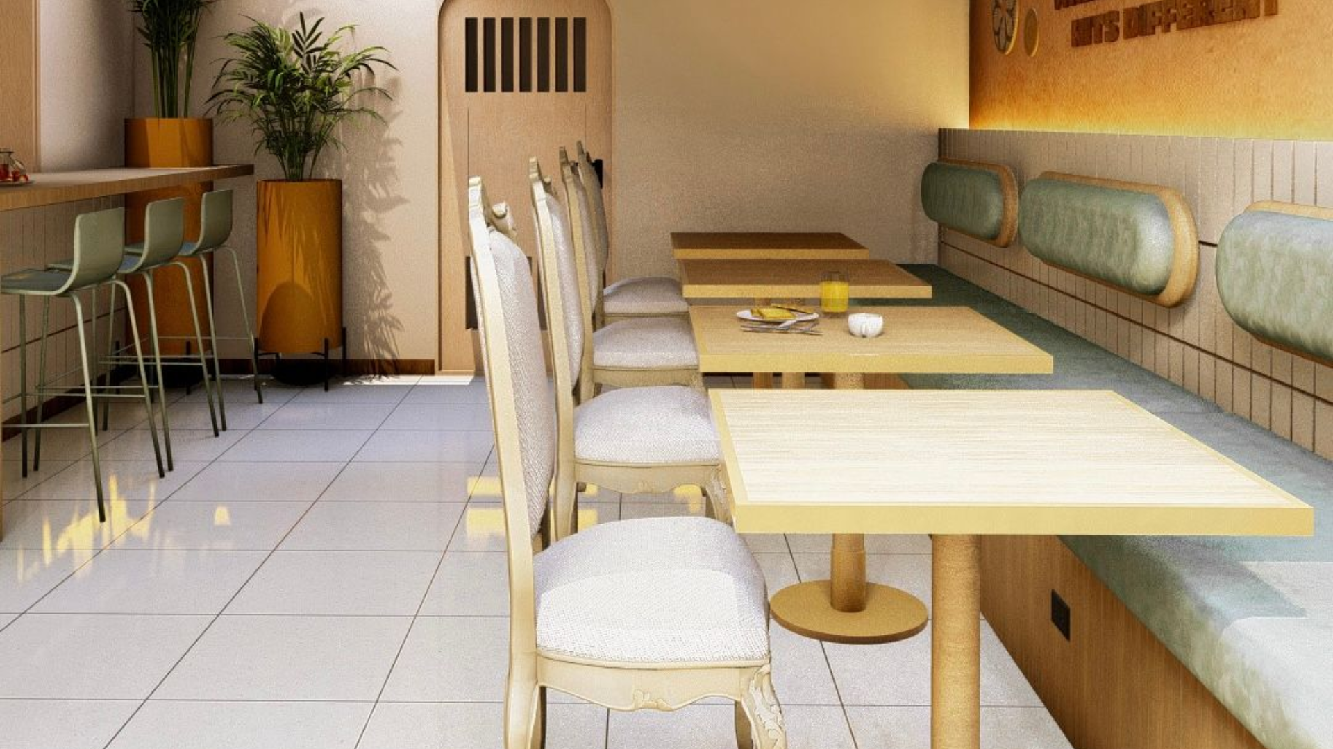 Interior de cafetería con mesas, sillas y barra. Predominan los colores beige y verde. La luz del sol entra a raudales.