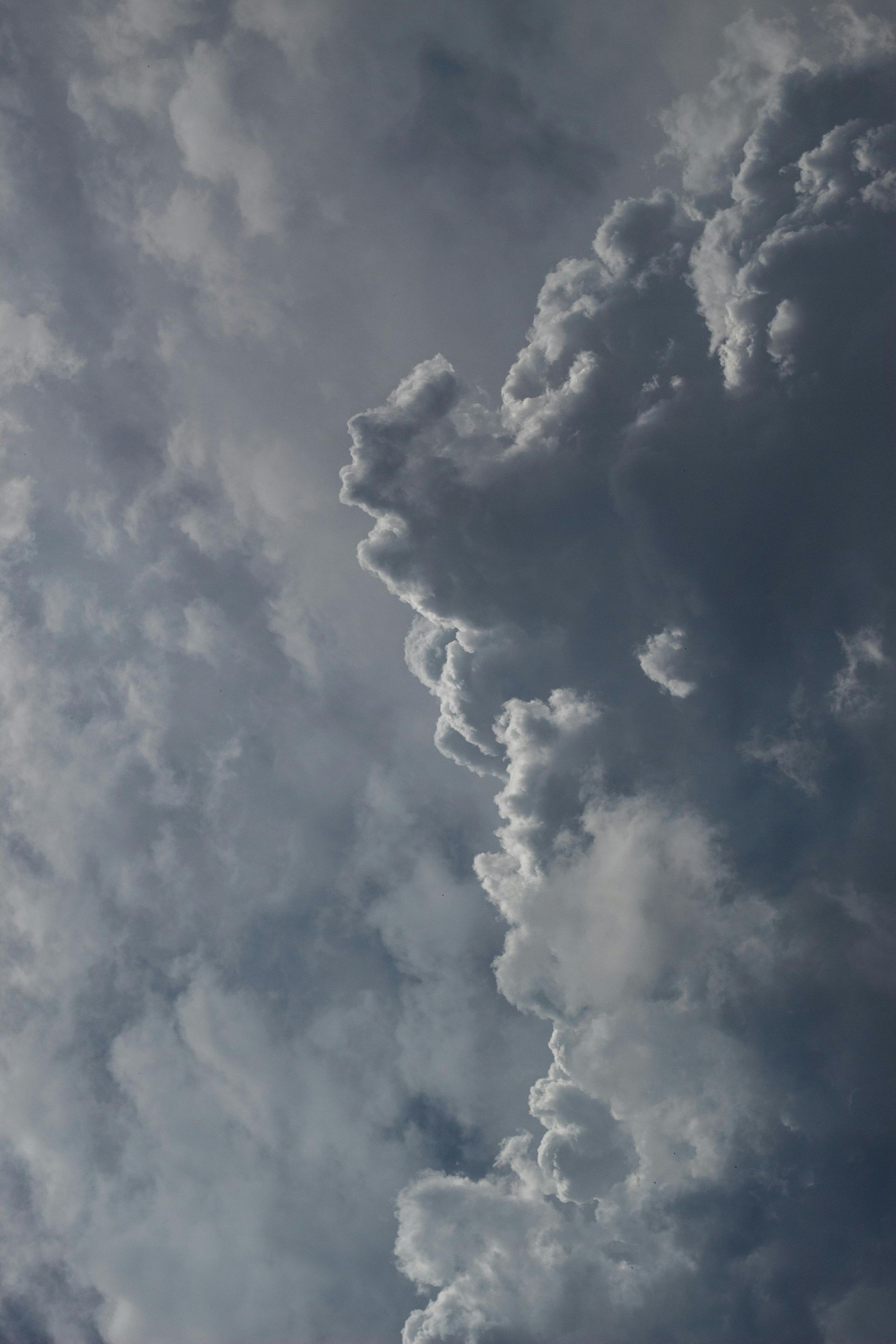 Dark, billowing clouds fill the sky, highlighted with bright white edges and patches of gray.