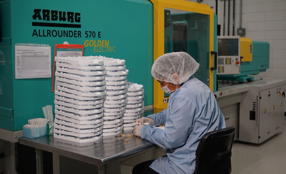 A woman is sitting at a table in front of a machine