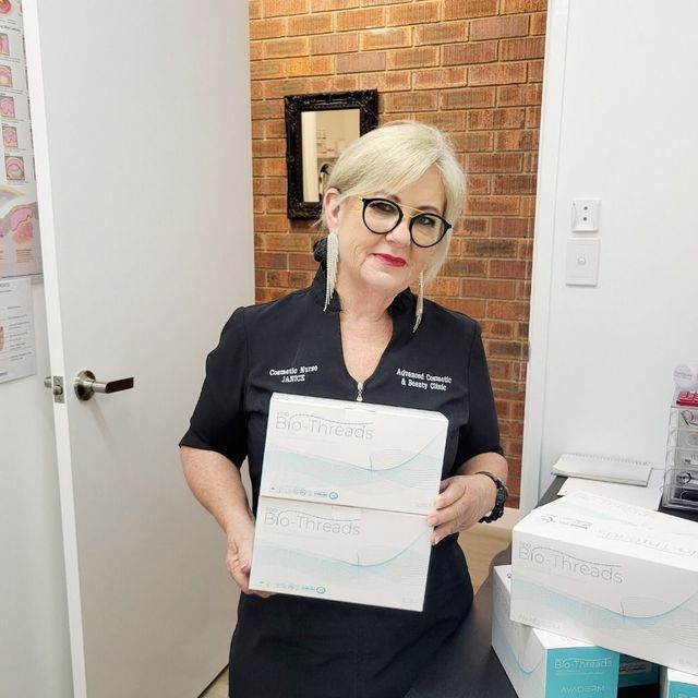 A Woman In A Black Shirt Is Holding A Box That Says ' Nc Trifecta ' On It — Advanced Cosmetic & Beauty Clinic in Bundaberg South, QLD