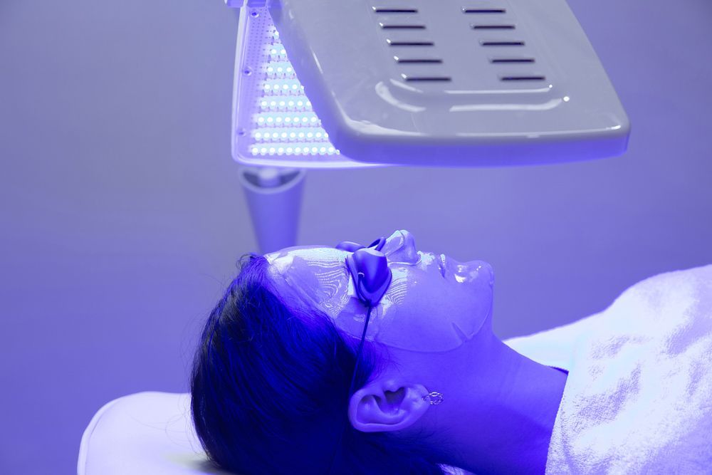 Woman is Getting a Blue Light Treatment on Her Face — Advanced Cosmetic & Beauty Clinic in Bundaberg South, QLD