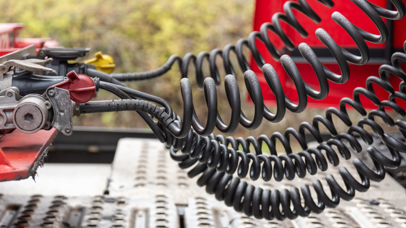 Black coiled air brake lines connected to a red semi-truck.