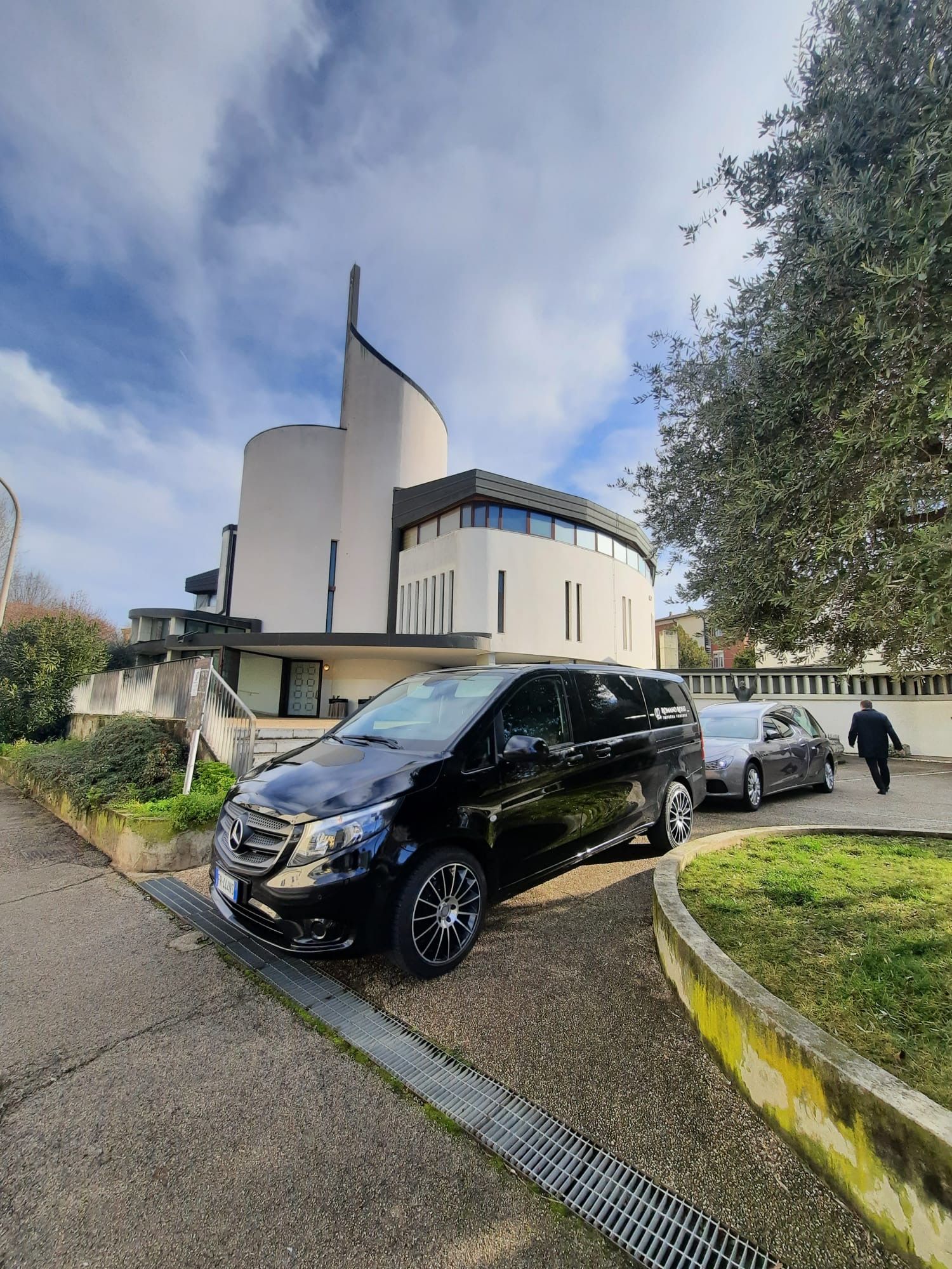 Un furgone funebre è parcheggiato davanti a un edificio.