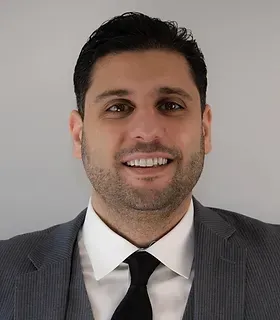 A man in a suit and tie is smiling for the camera.