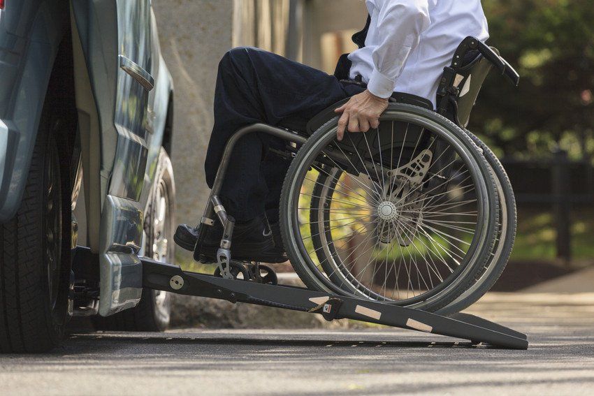 Caucasian businessman in wheelchair entering vehicle