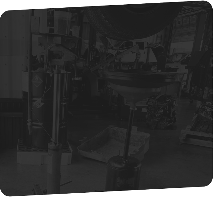 Workshop interior, machinery visible, dimly lit, possibly industrial setting.