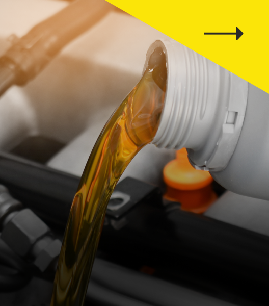 Oil being poured from a white bottle into a car engine.